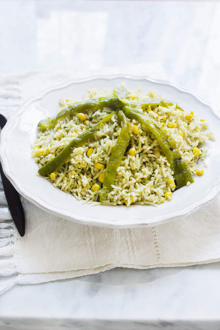 A plate with mexican green rice prepared with chile poblano, corn and cilantro — Stock Photo