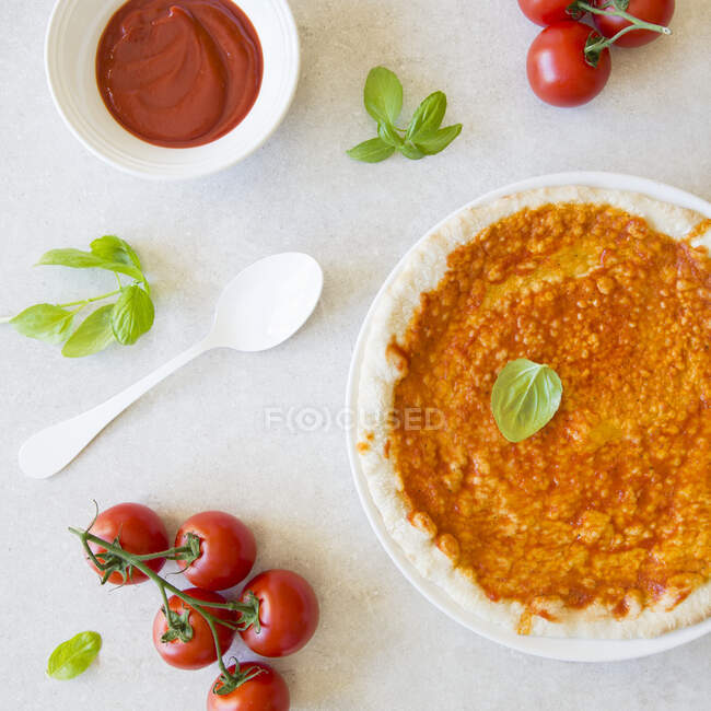 Primer plano de deliciosa pizza sin cocer con salsa de tomate - foto de stock