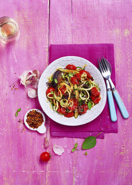 Courgetti with roast vegetables, onions, tomato, asparagus, garlic and topped with micro herbs and chili flakes — Stock Photo