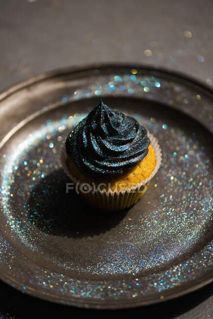 Un cupcake à la crème au beurre noir et aux paillettes — Photo de stock
