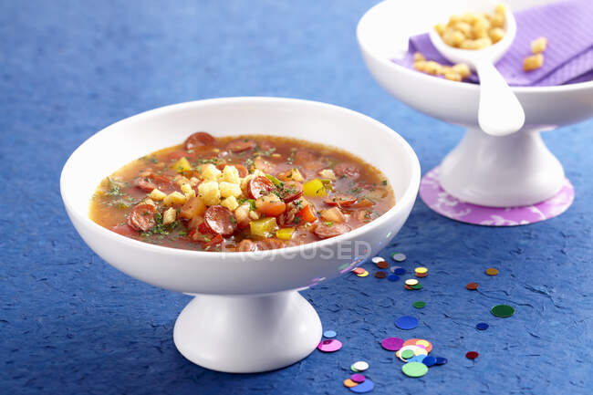 Перцовый суп с колбасными ломтиками и перцовыми гренками — стоковое фото