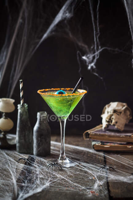 Children's cocktail made from green jelly and apple juice decorated with an eye sweet for Halloween — Stock Photo