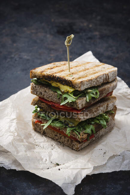 A vegan sandwich with grilled peppers, rocket and cheese substitute — Stock Photo