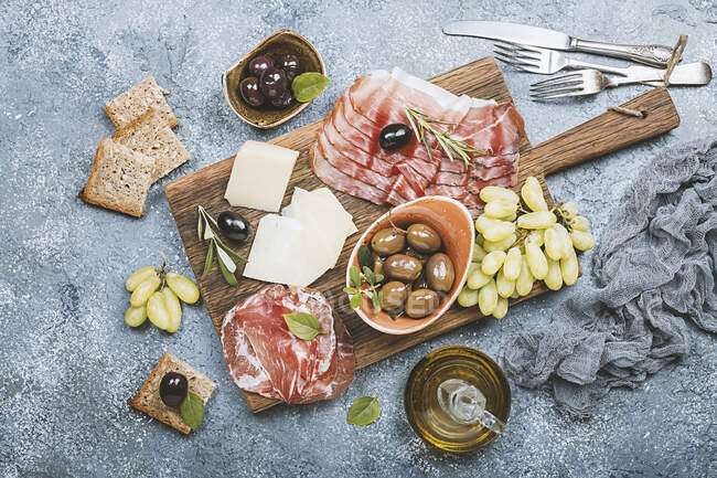 Typical italian antipasto - prosciutto, ham, cheese and olives — Stock Photo