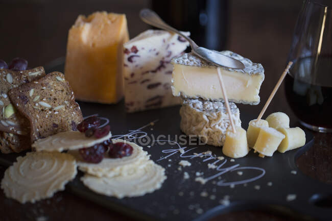 Сырная доска натюрморт с крекерами, клюквой и вином — стоковое фото