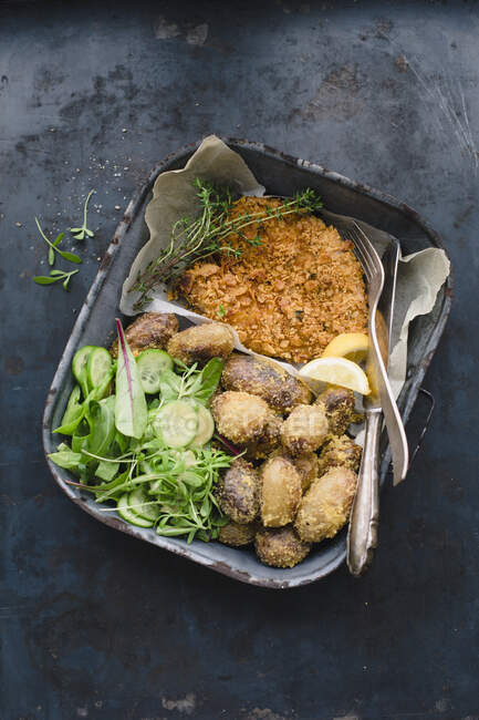 Chicken escalope with a cornflake coating, polenta potatoes and salad in a baking tin — Stock Photo