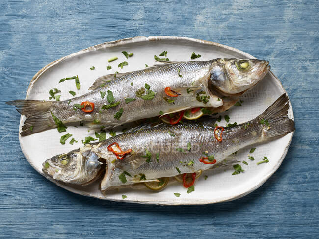 Fresh fish with lemon and dill on wooden background — Stock Photo