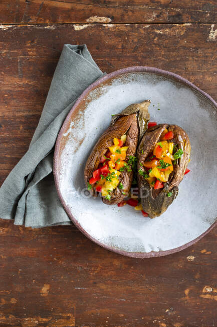 Baked eggplant with vegetables and spices on a wooden background. top view. — Stock Photo