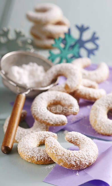 Vanillekipferl mit Zuckerpulver im Sieb — Stockfoto