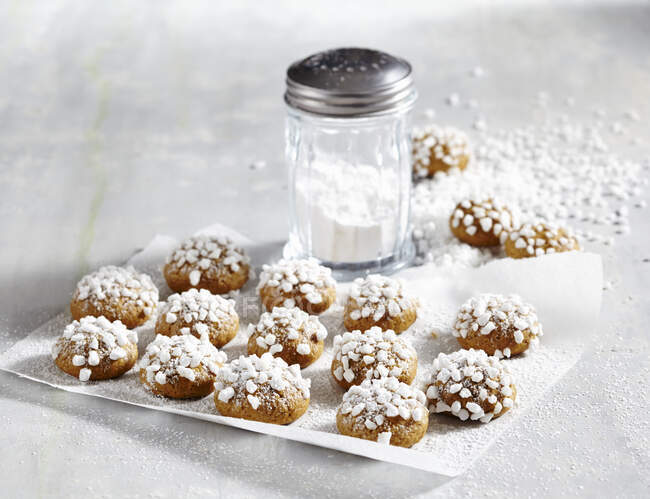 Biscuits with sugar nibs and sugar powder in glass sift — Stock Photo