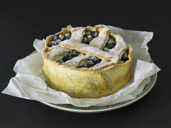 A freshly baked berry cake on baking paper — Stock Photo