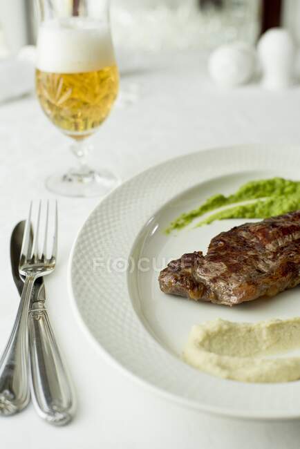 Grilled beef steak with celery puree and pea puree — Stock Photo