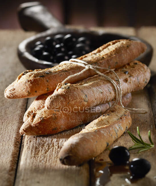 Baguette di olive avvolte in spago con olive nere — Foto stock