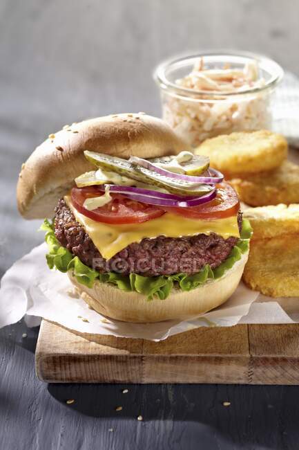Una hamburguesa con queso y ensalada de col, primer plano en la mesa - foto de stock