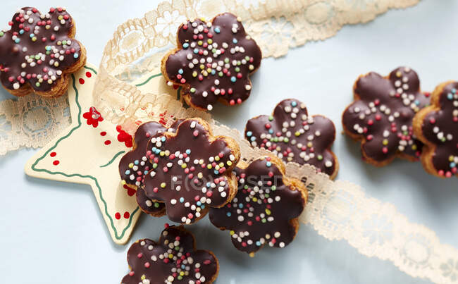 Flowers shaped cookies with chocolate glaze and sprinkles — Stock Photo