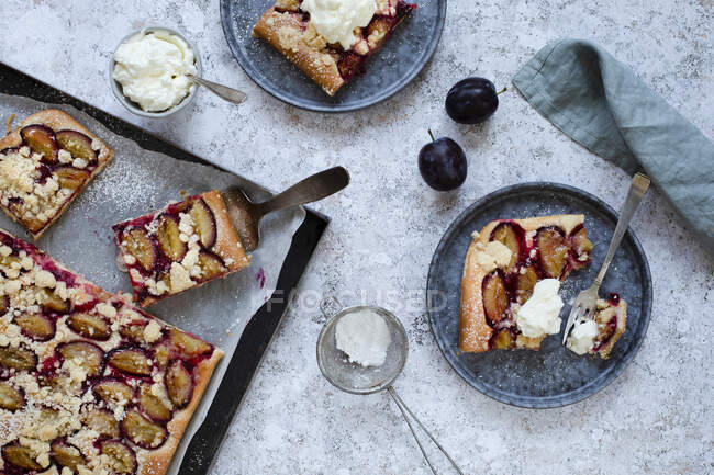 Two slices of damson tray bake cake with icing sugar and cream — Stock Photo