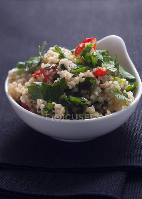Bol blanc de salade Tabouli à la menthe, persil, tomates et citron — Photo de stock