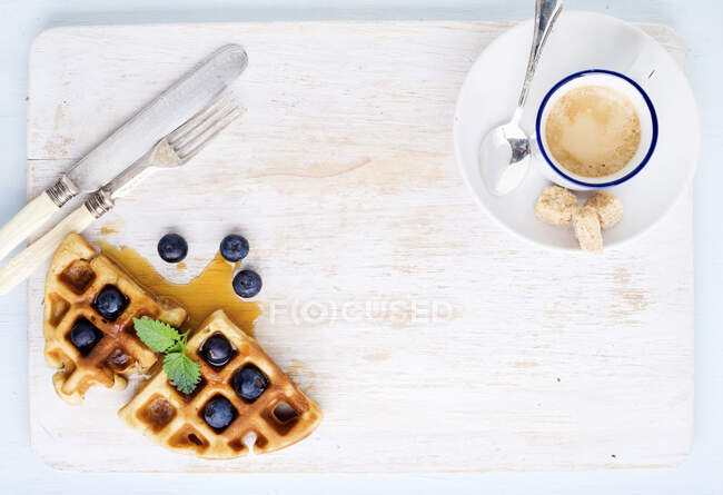 Espresso coffee cup and soft Belgian waffles with fresh blueberries and marple syrup — Stock Photo