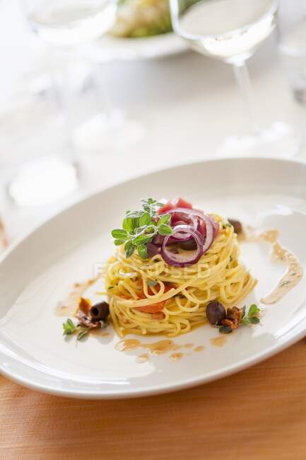 Tagliolini with fresh tomato sauce and olives — Stock Photo