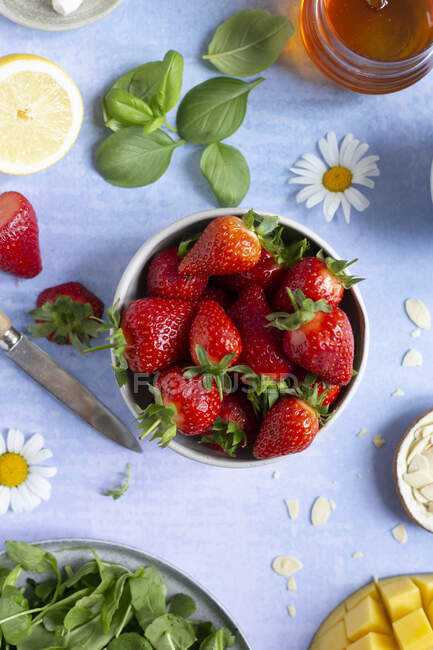 Small bowl of fresh strawberries on a vibrant background — Stock Photo