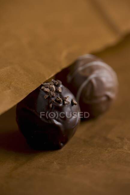 Close-up de uns doces de chocolate em um fundo de madeira. — Fotografia de Stock