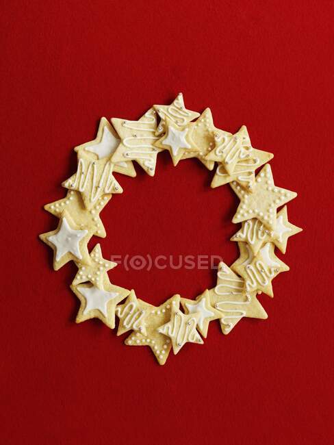 Couronne faite de biscuits étoiles sur fond rouge — Photo de stock
