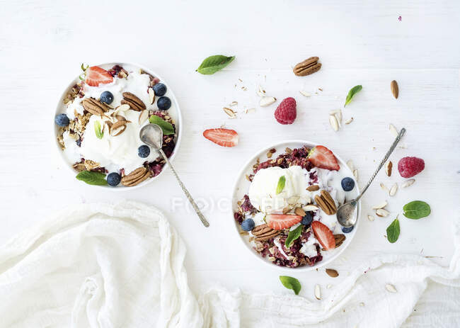 Crumble desserts with fresh blueberries, raspberries, strawberries, walnuts, pecans, yogurt, and mint — Stock Photo
