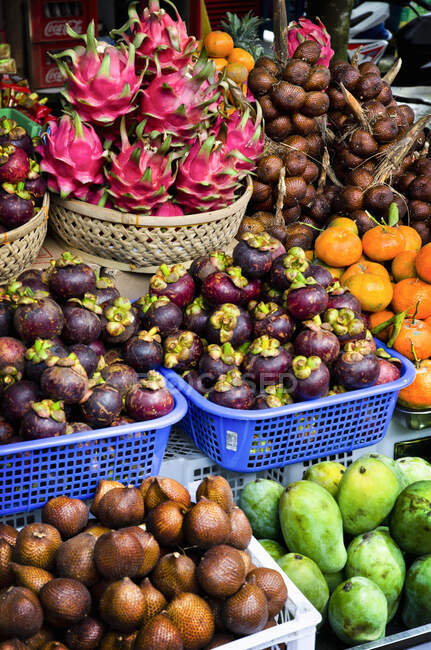 Un primer plano de un puesto de frutas en Bali, Indonesia con cestas de fruta de serpiente, fruta del dragón, mangosteno, papaya y naranjas amargas balinesas - foto de stock