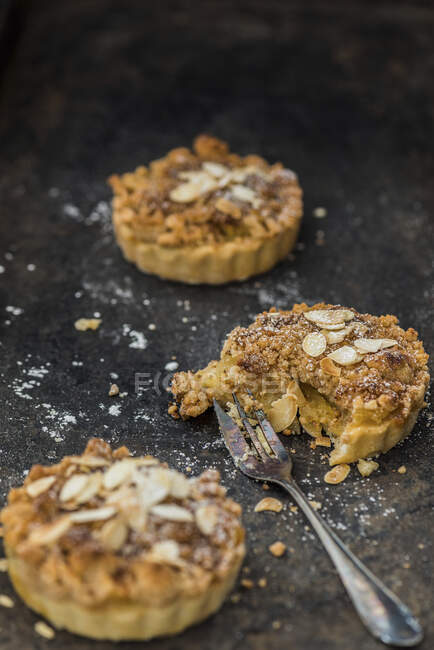Apple tartlets with flaked almonds — Stock Photo