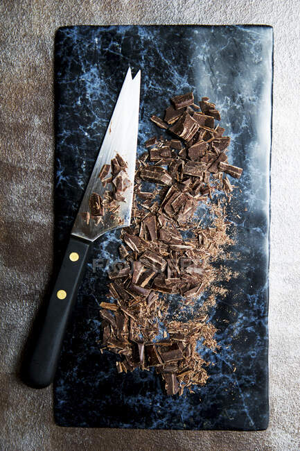 Chocolate picado con un cuchillo - foto de stock