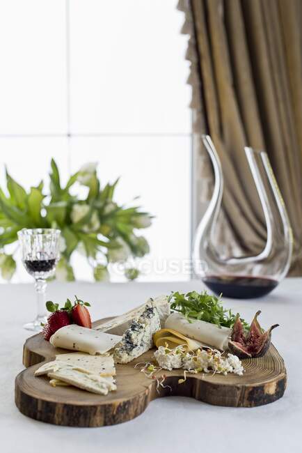 Cheese board with fresh figs, rocket, strawberries and red wine - foto de stock