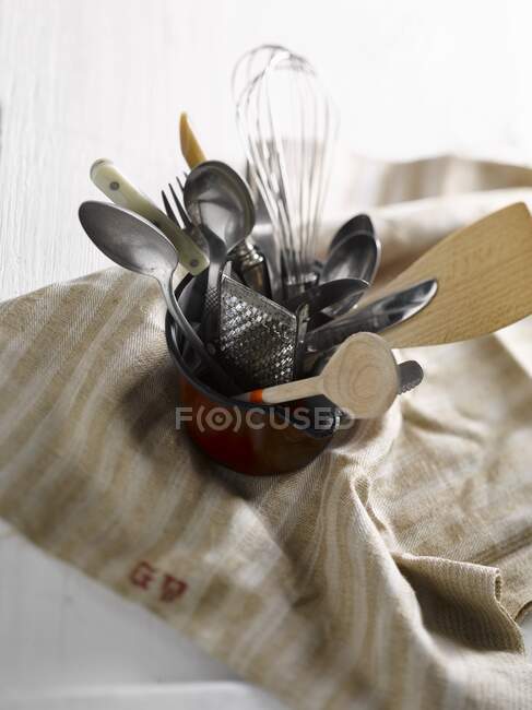 Une petite cruche avec de vieux ustensiles de cuisine — Photo de stock