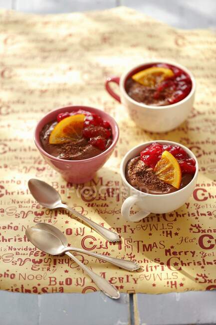 Chocolate mousse with cranberries jam and orange slices in mugs — Stock Photo