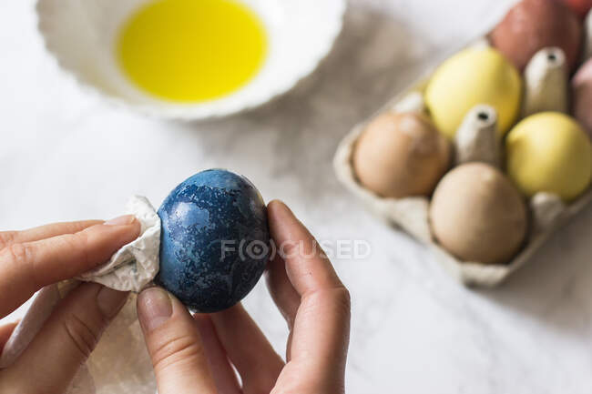 Polishing egg with oil, egg dyed with red cabbage — Stock Photo