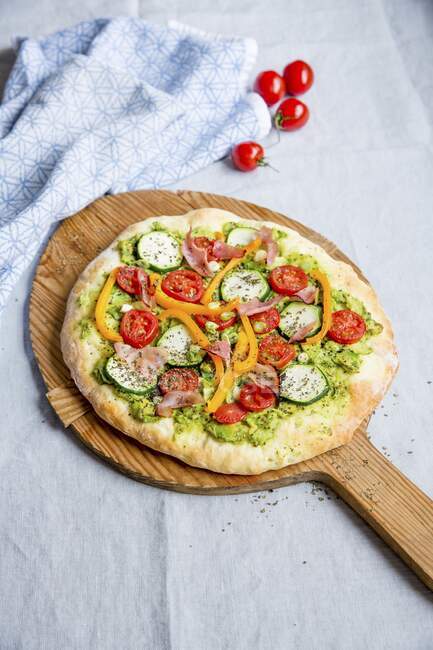 Pizza with avocado, zucchini, tomatoes, peppers and ham — Stock Photo