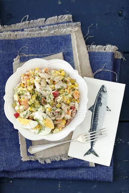 Egg, potato, corn, green peas and carrot salad with smoked mackerel and mayo sauce — Stock Photo