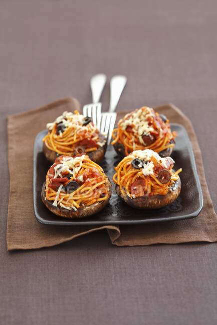 Cogumelos portobello assados recheados com esparguete com chouriço e azeitonas pretas — Fotografia de Stock