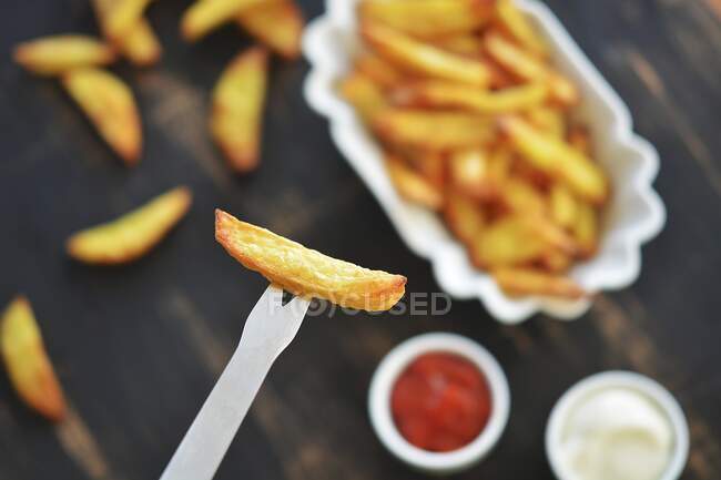 French fries on a fork and in a bowl — Stock Photo
