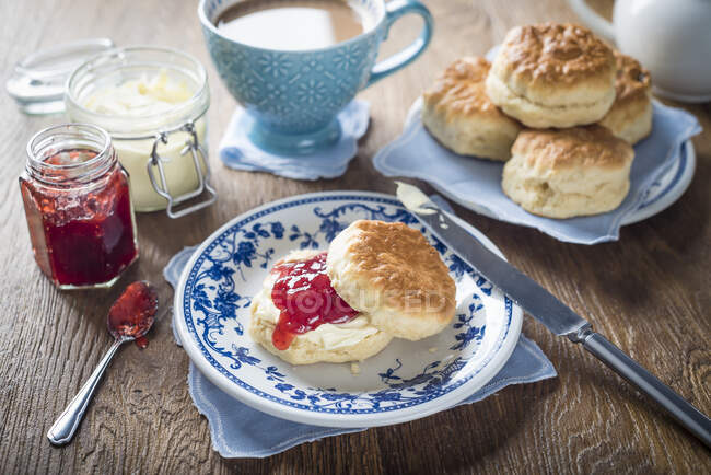 Scones with strawberry jam and clotted cream and tea — Stock Photo