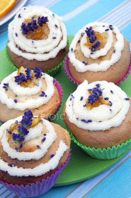Lavender cupcakes with cream, marmelade and flowers — Stock Photo