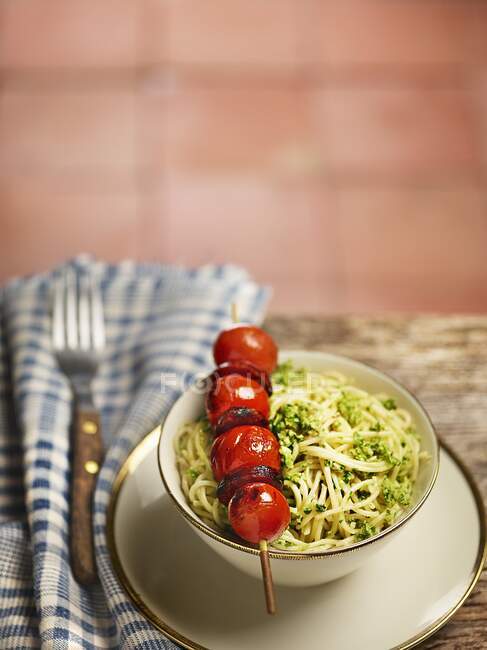 Capellini with pesto and a cherry tomato and chorizo ??skewer — Stock Photo