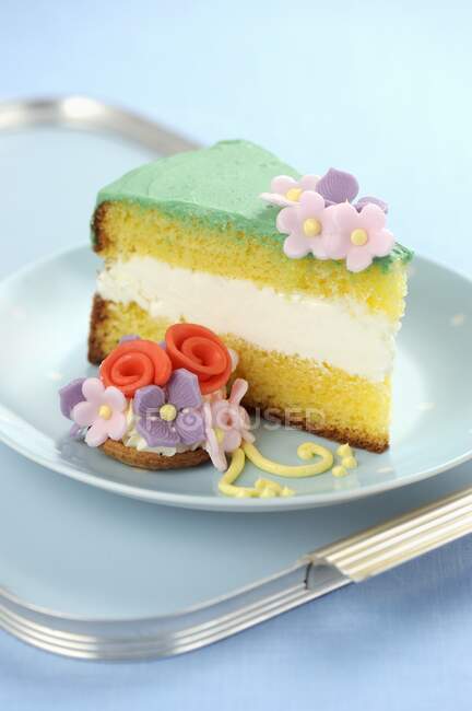 Ein Stück Genueser Kuchen mit Fondant-Blumen — Stockfoto