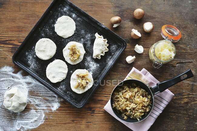 Maultaschen, German pasta dish on a baking sheet, with dough and ingredients beside it — Stock Photo