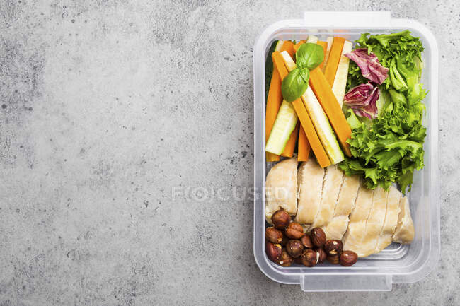 Boîte à lunch saine avec poitrine de poulet, noix, salade et bâtonnets de légumes — Photo de stock