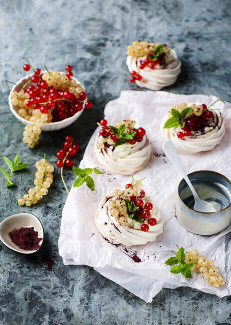 Mini pavlovas with whipped cream and redcurrants — Stock Photo