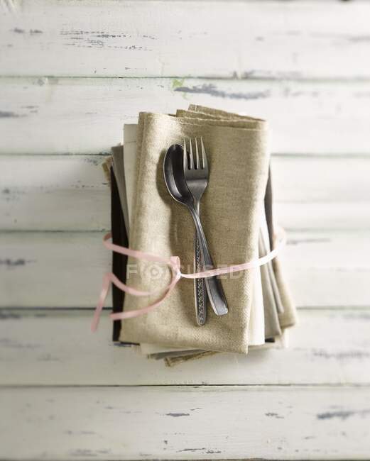 Una cuchara vieja con un tenedor en servilletas de lino - foto de stock