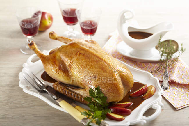 Roasted goose for Christmas dinner filled with apple stuffed and served with apple wedges — Stock Photo