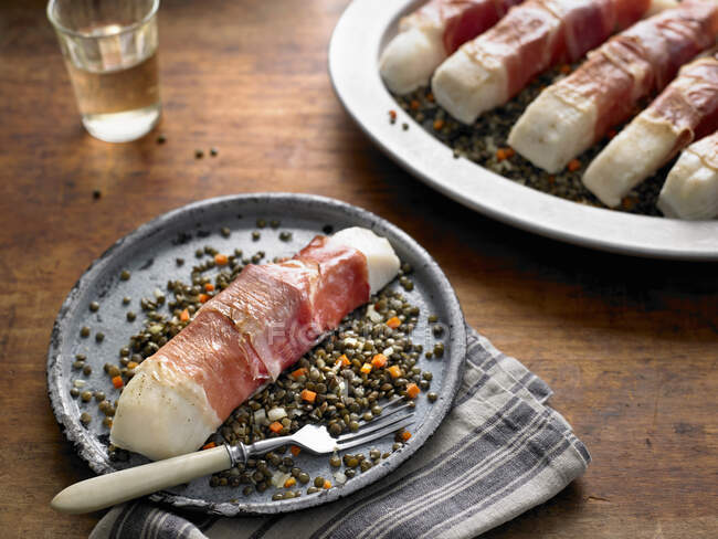 Bacalhau assado com Prosciutto sobre lentilhas francesas com alho e tomilho — Fotografia de Stock