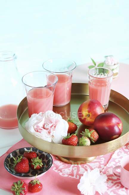 Strawberry and nectarine smoothies on a golden stand — Stock Photo