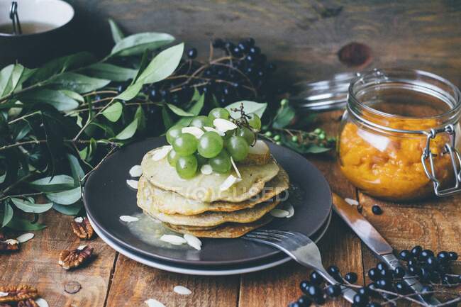 Gestapelte Pfannkuchen mit Trauben und Mandelflocken — Stockfoto